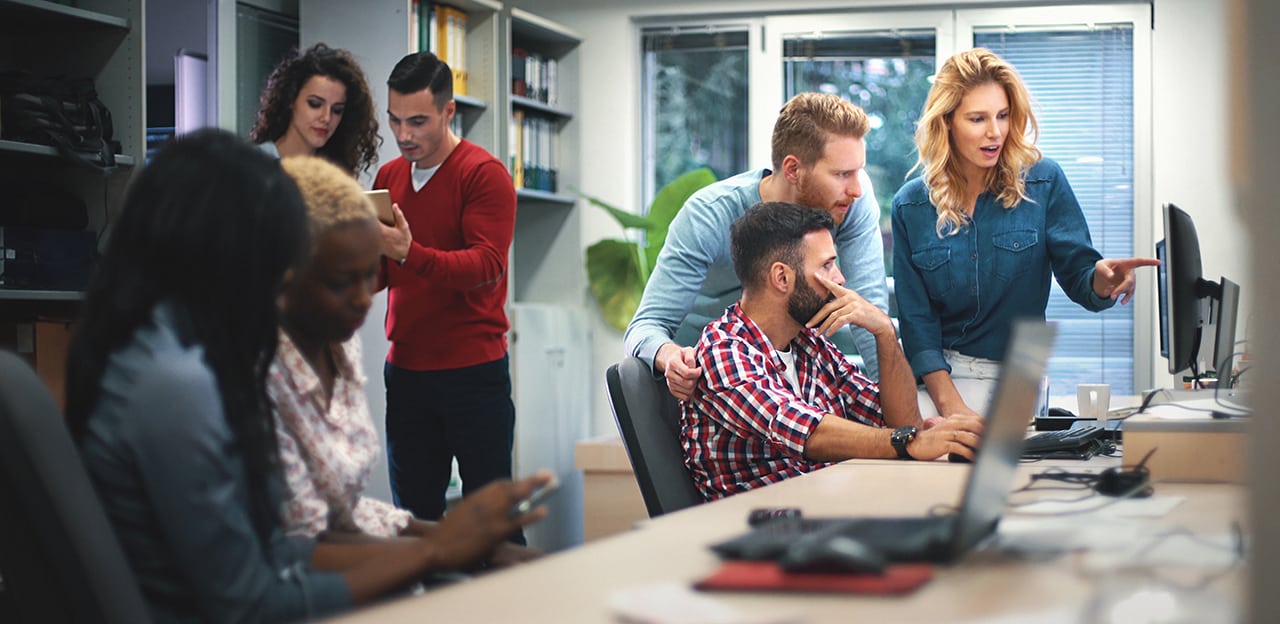 A team meeting and collaborating on several computers